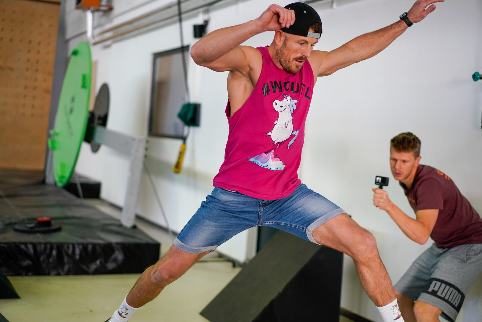 Athlet in pinkem Woutl-Shirt macht einen weiten Sprung