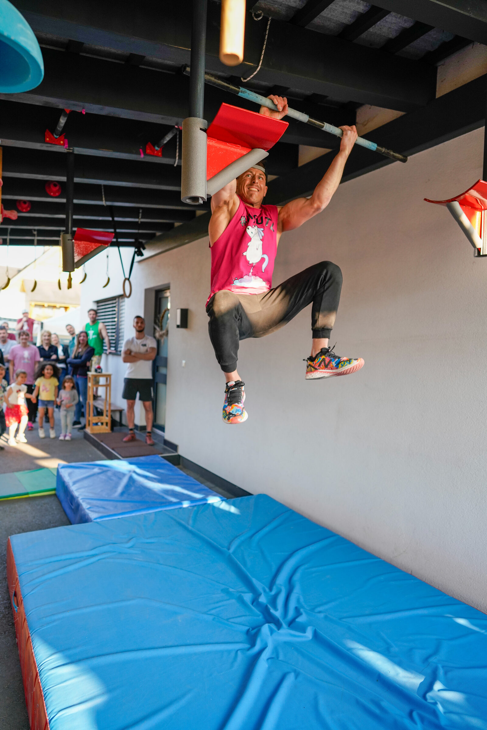 Athlet springt zu einer horizontalen Stange indoor