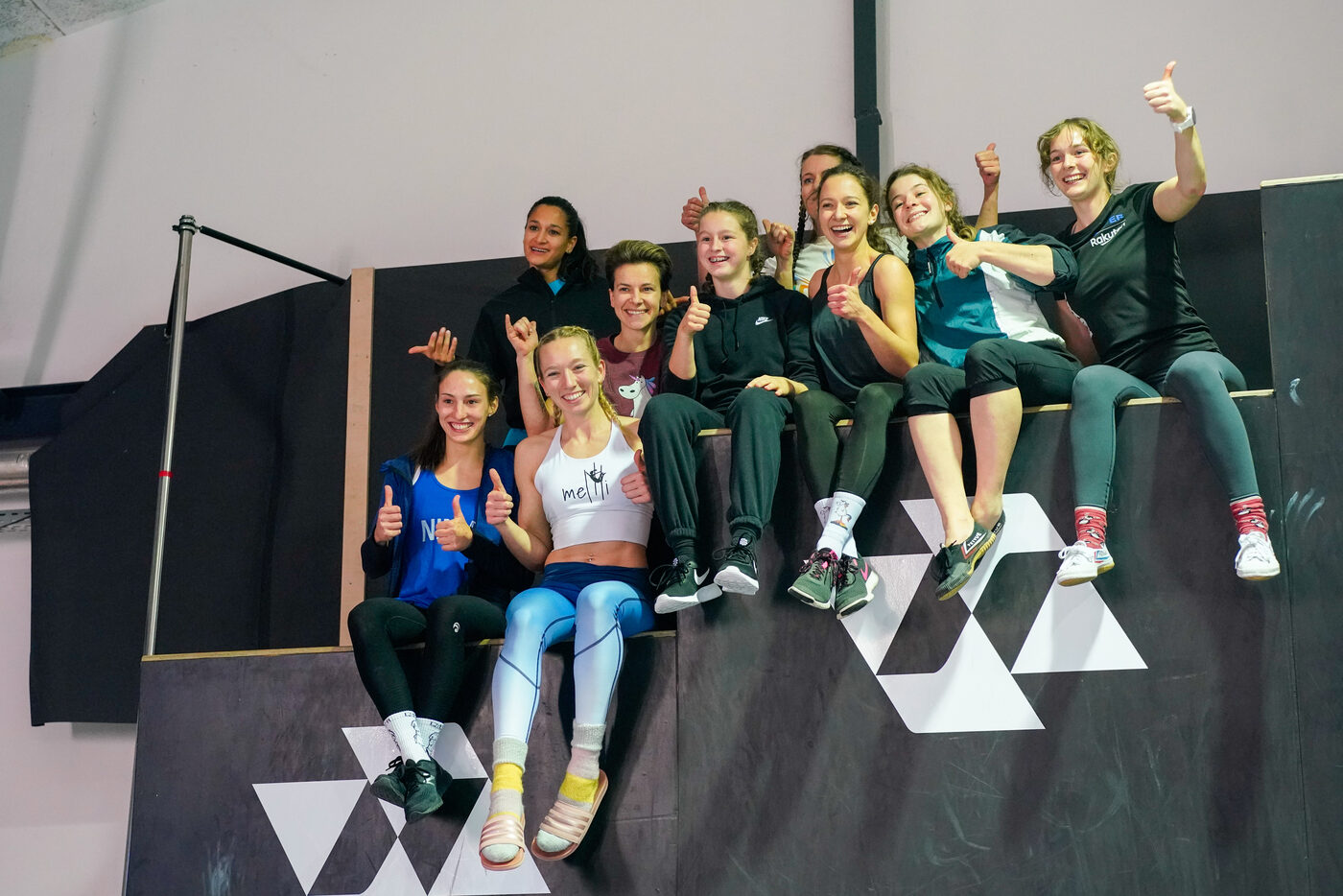 Gruppe von Athletinnen lacht und zeigt Daumen nach oben