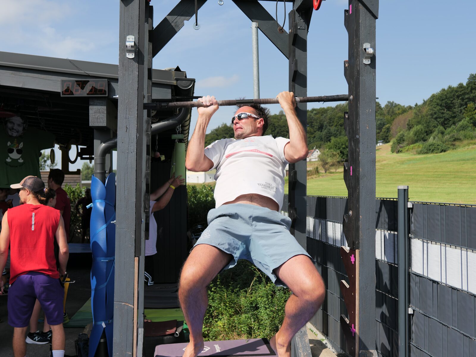 Athlet macht Klimmzüge an einer Outdoor-Ninja-Anlage