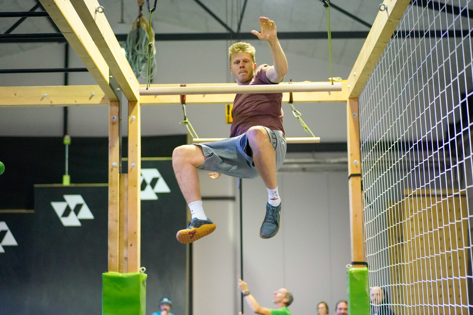 Athlet im Sprung über einen Holzbalken