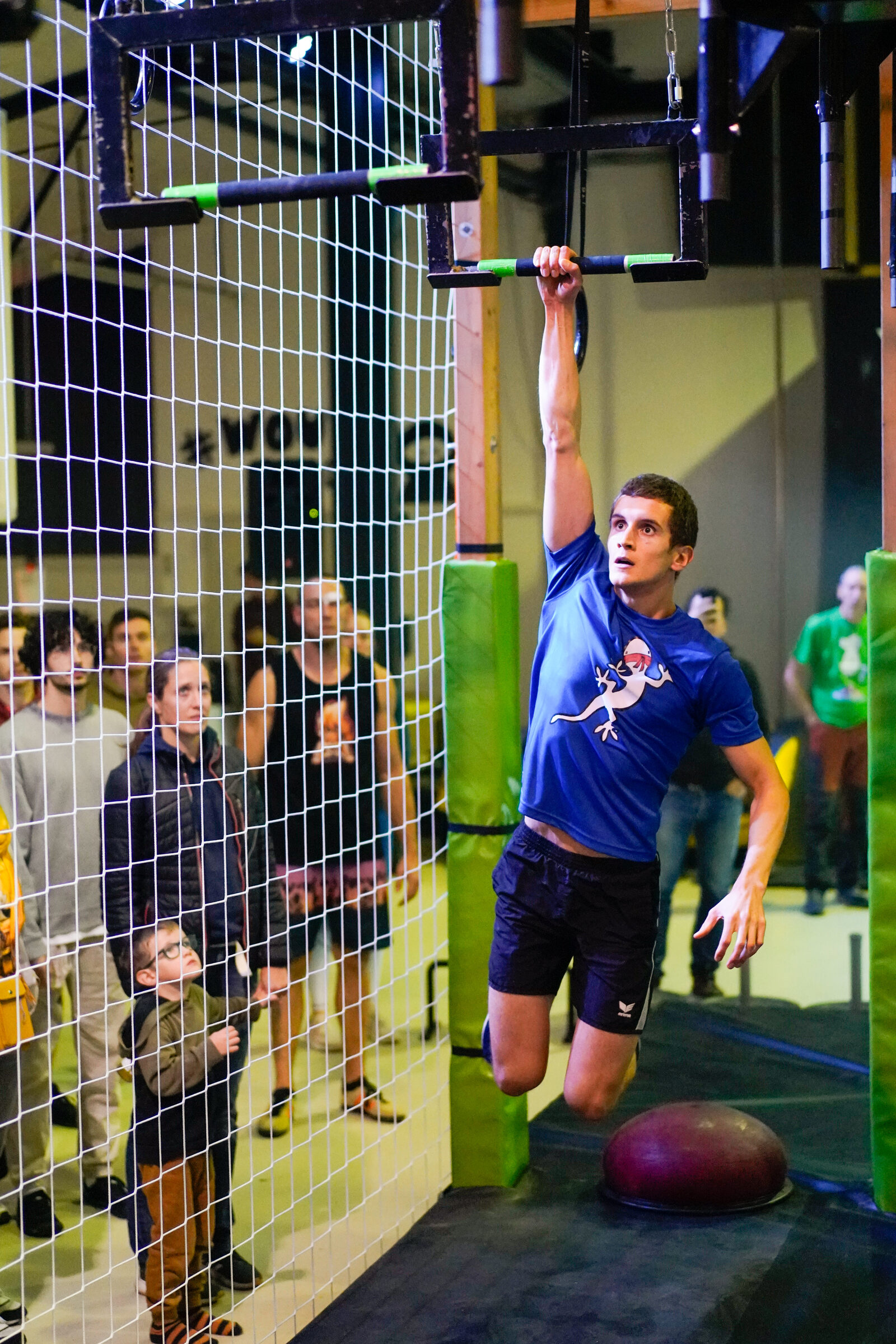 Athlet springt zu einer Stange über einer Netzkonstruktion