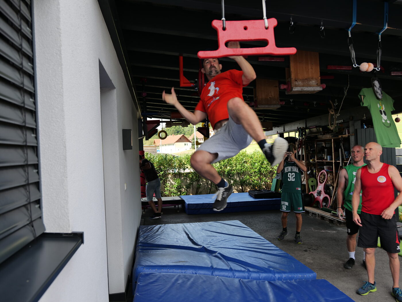 Athlet im Sprung vor einer roten Griff-Konstruktion