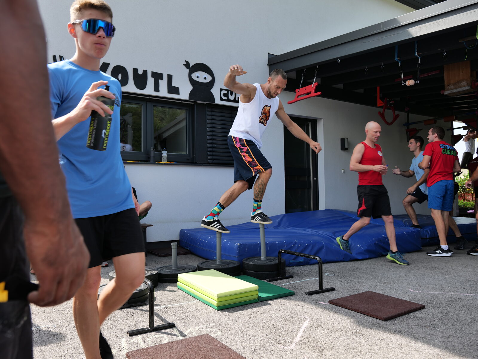 Athlet:innen springen über Stepping-Stones bei einem Outdoor-Bewerb